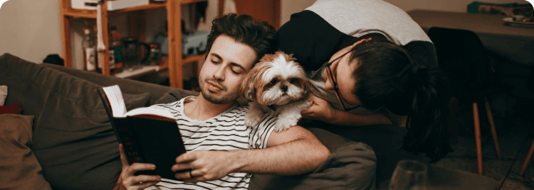 Casal no sofá com seu cachorro